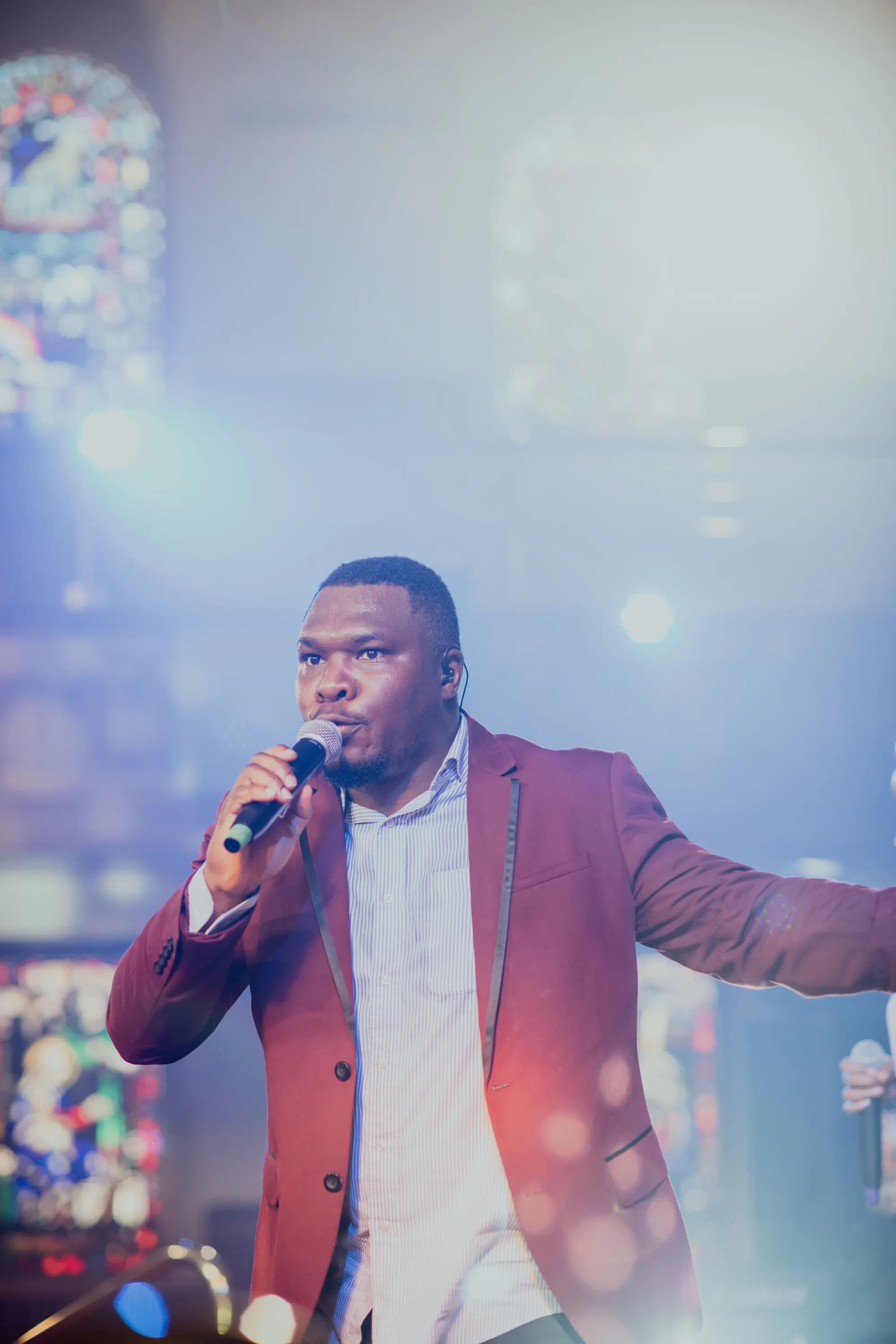 Maxwell AU singing into a microphone mid-worship.