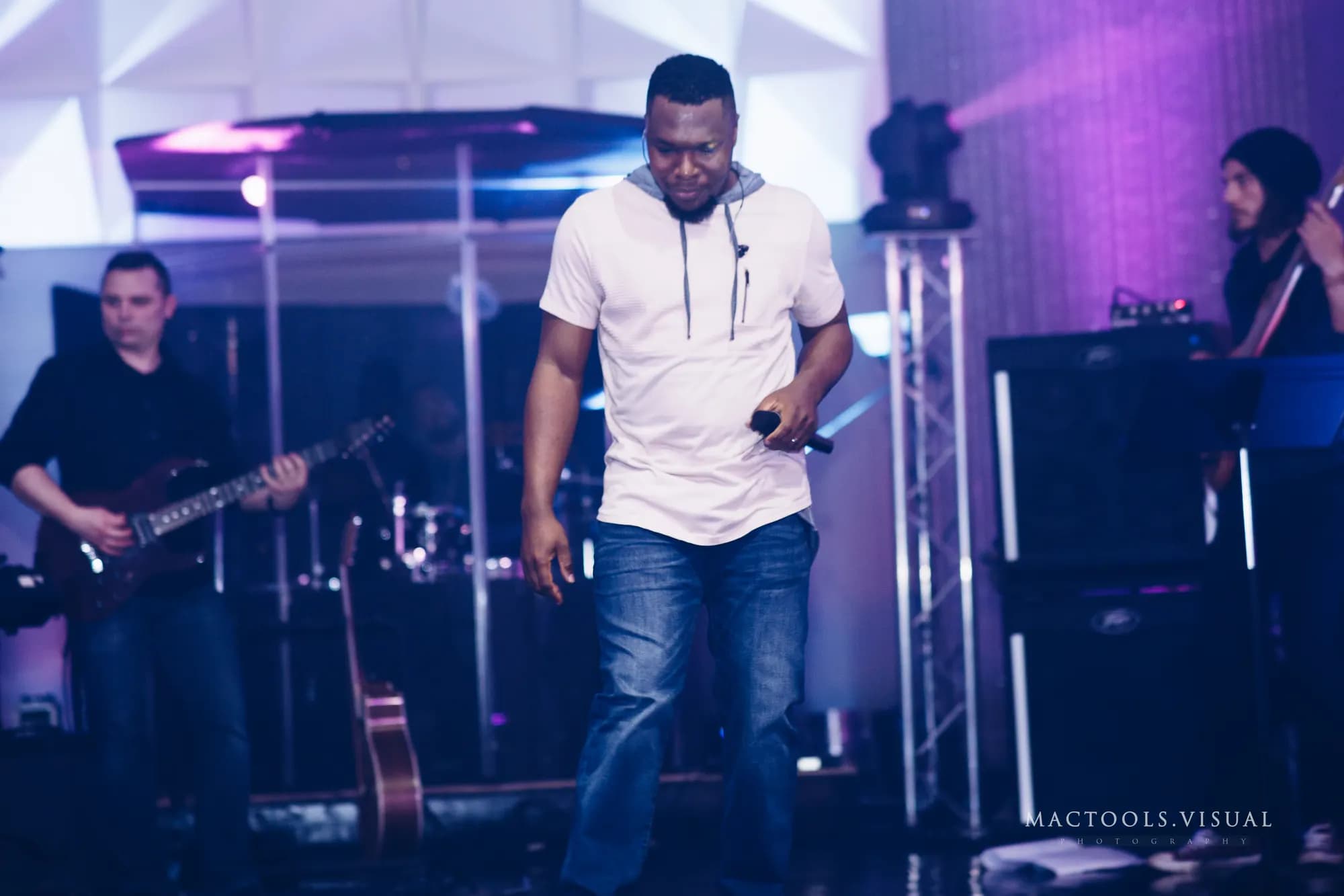 Maxwell AU leading a congregation with the band behind him.